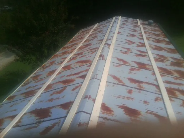 Rusted metal roof panels with new wood purlins before replacement — Storm Damage Roof Repair in Peck by Roofing Brothers